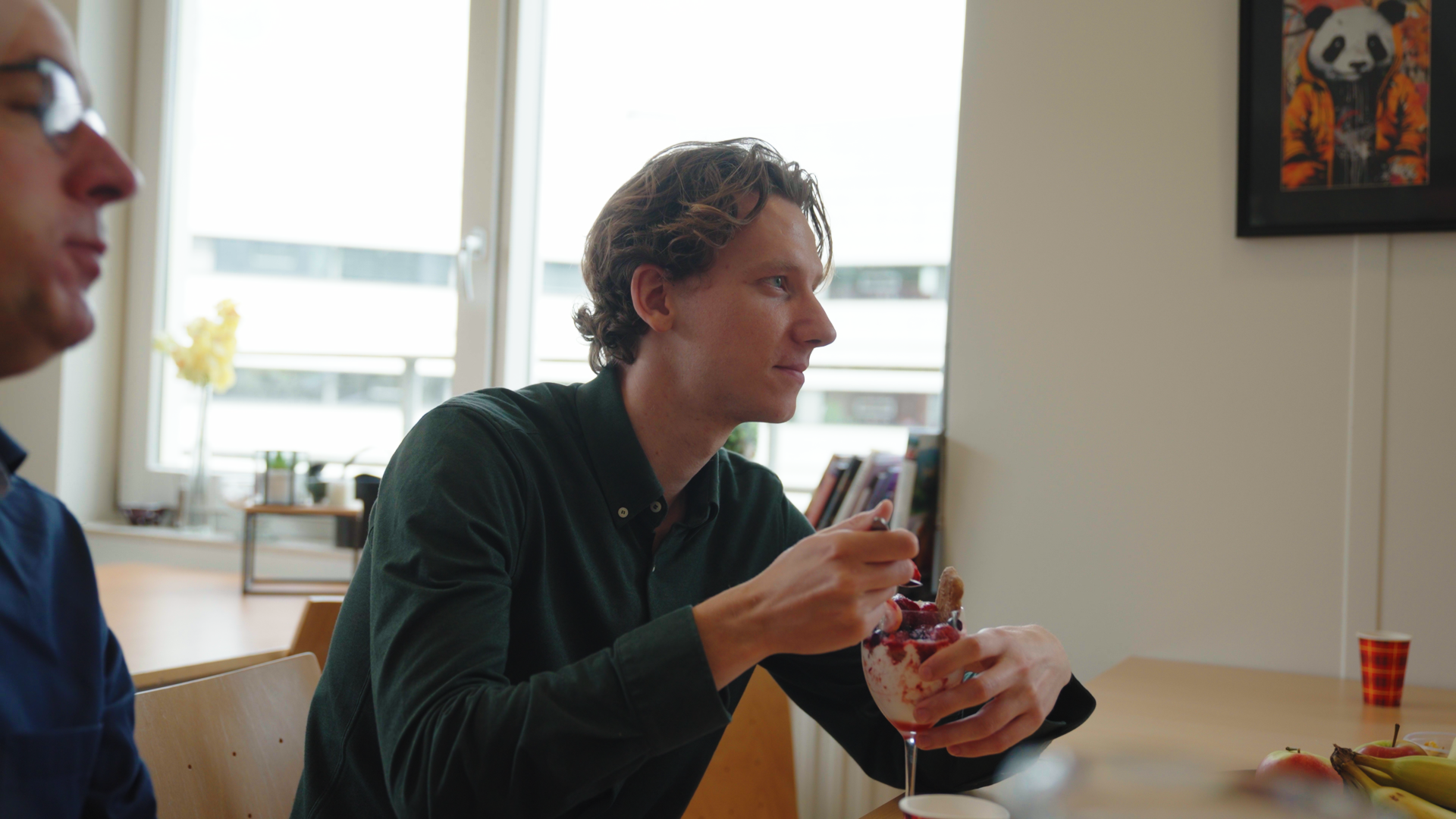 Sam in overleg met collega's tijdens een teamoverleg.