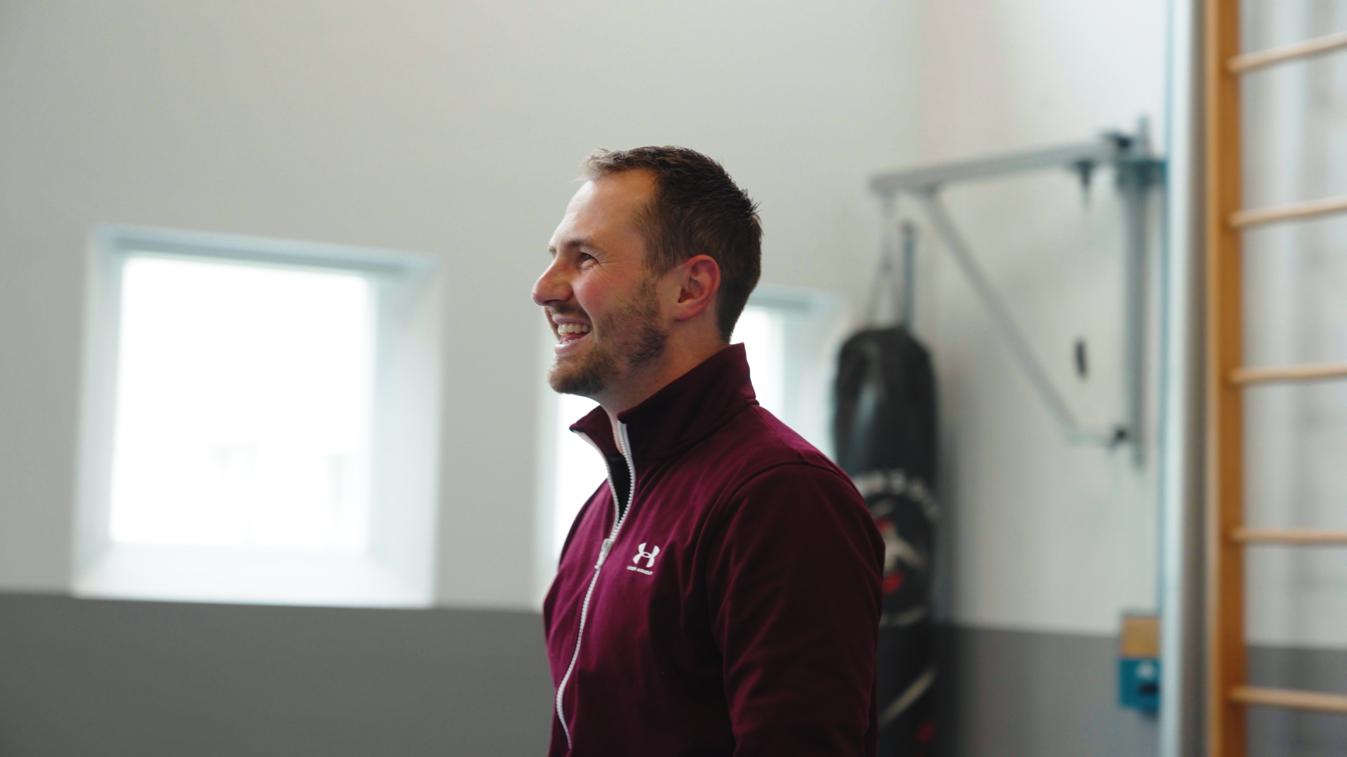 Collega lacht tijdens een energiek moment in de sportruimte.